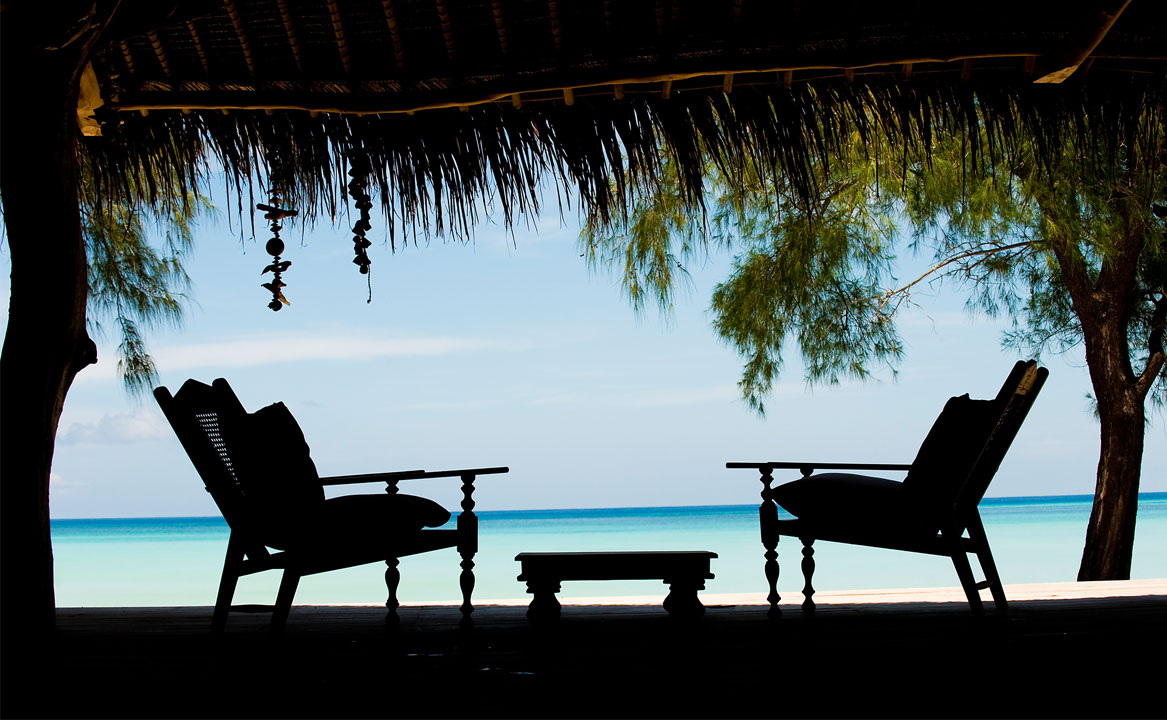 A table and 2 chairs make the ideal desert island picnic spot on a beach on Vamizi Island.