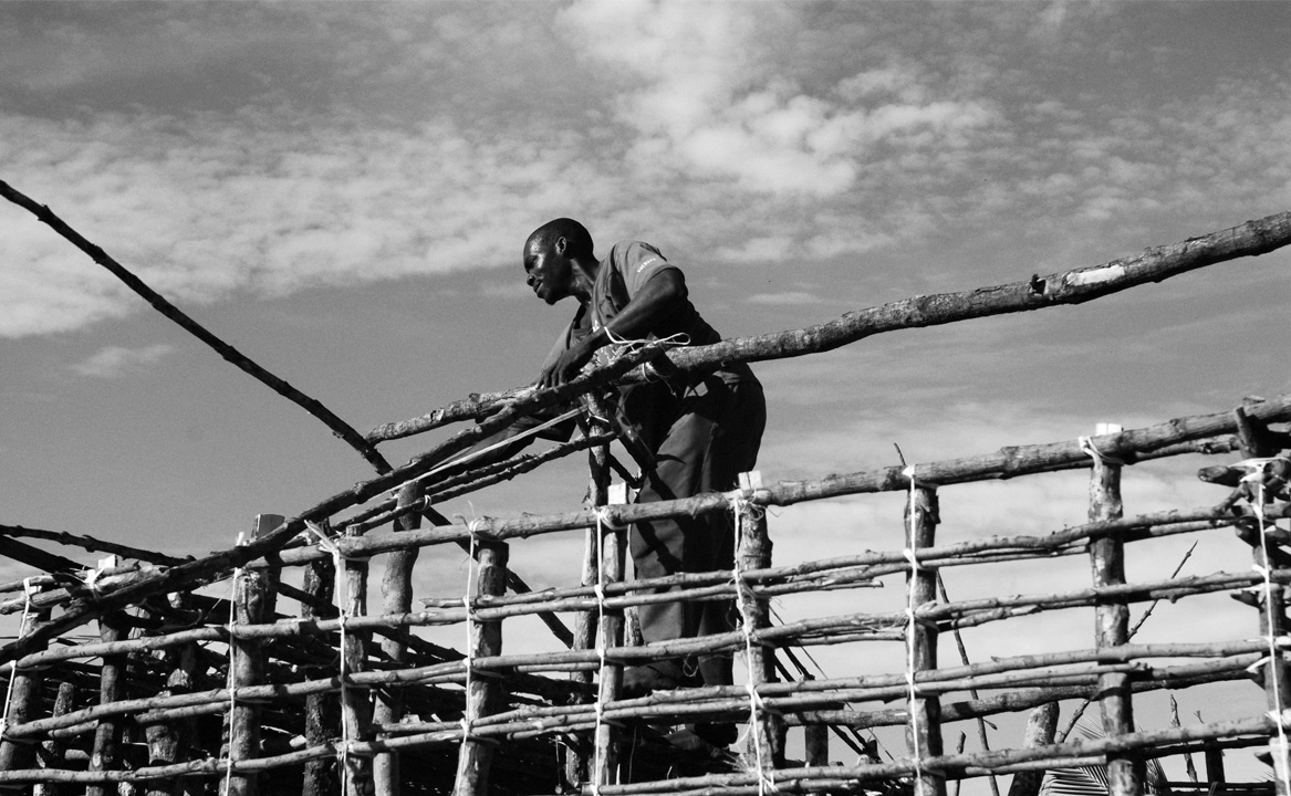 A Vamizi Islander builds a wall out of traditional materials.